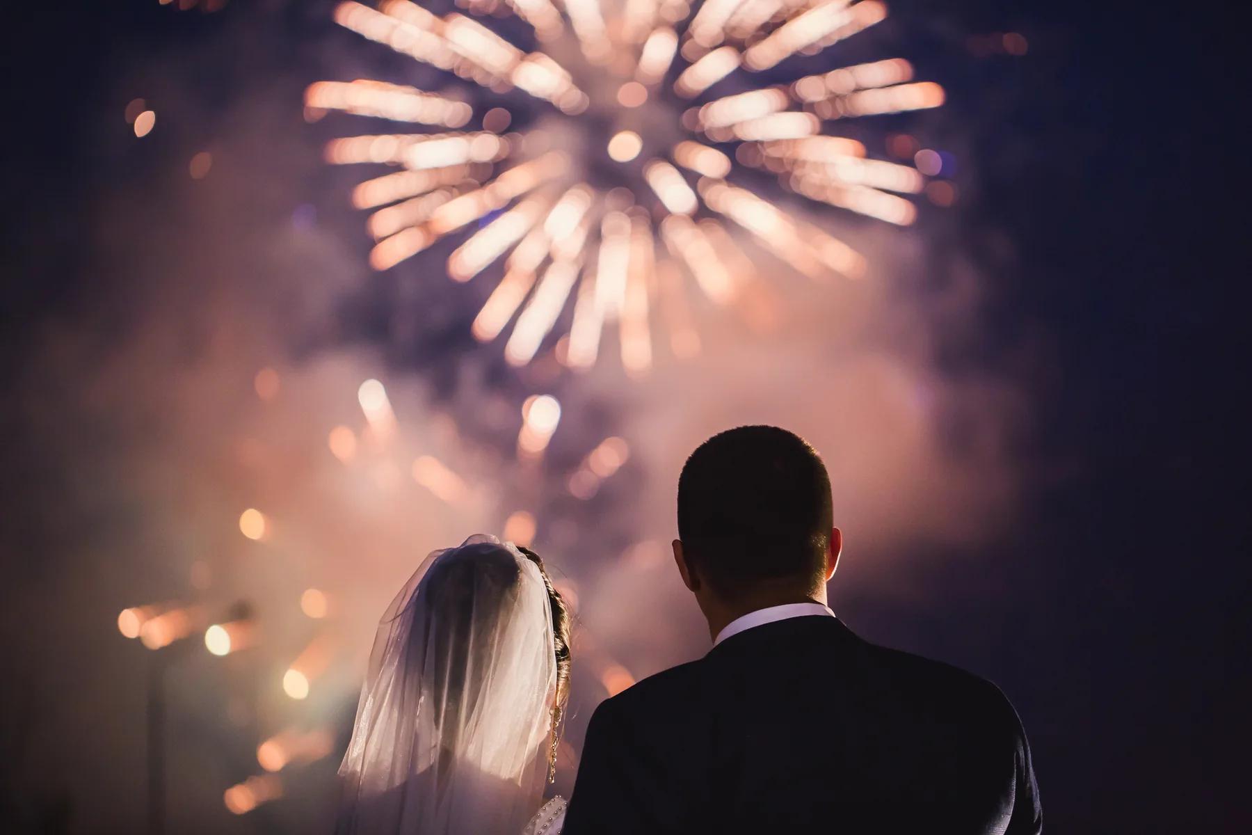 Bride and groom watching wedding fireworks